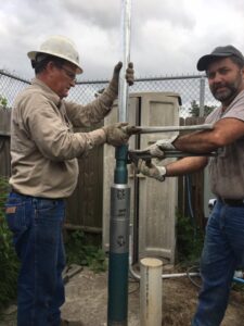 Two men doing water well service